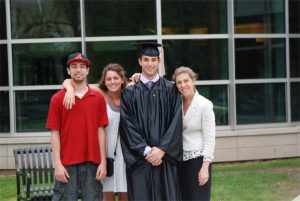 Family with college student in graduation cap and gown